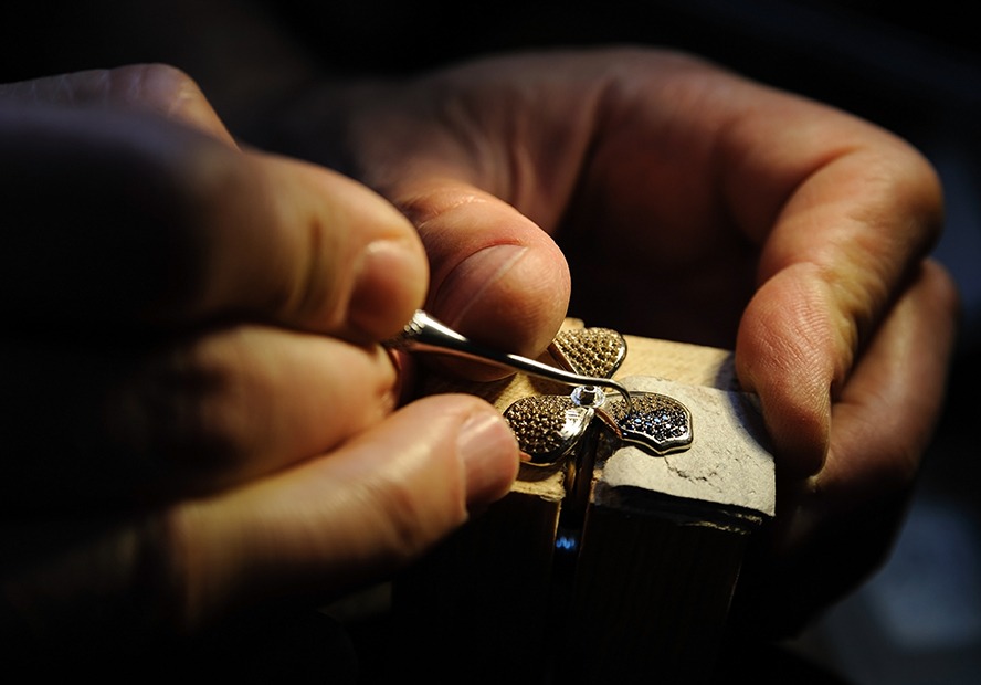 Craft jewelery making. Jeweller fixes sapphires on the ring.